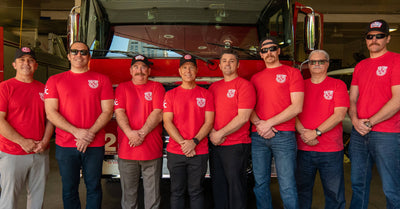 Crew members of CalFire standing together in front of a firetruck.
